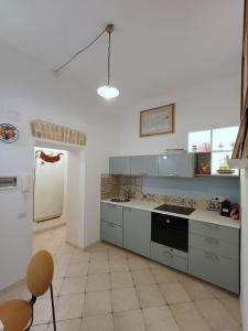 cocina con armarios grises y horno con fogones en Gianicolo Sweet Home, en Roma