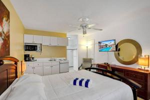 a bedroom with a large bed with a ceiling fan at Waves Beach Town Cozy Studio Apartment in Pompano Beach