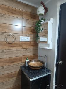 a bathroom with a sink and a wooden wall at Zoey's Hill View in Navi Mumbai