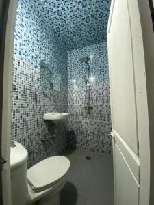 a blue tiled bathroom with a toilet and a sink at Hotel Dar Youssef 1 in Marrakech