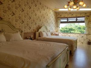 una camera da letto con due letti e una finestra di 花蓮晨風星語民宿Sun Star B&B a Ji'an