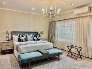 a bedroom with a large bed and a chandelier at The Stella Guest House & Spa in Ermelo