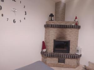 a brick fireplace with a clock on the wall at Гостьовий двір in Yaremche