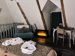 a bedroom with a bed and a chair and a fireplace at Domaine le Manoir, gîtes de charme et de caractère avec piscines privatisées et spa nordique in Fossemagne +64 photos