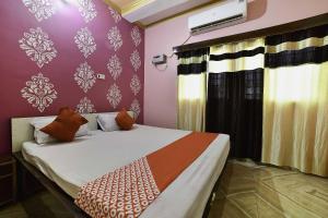 a bedroom with a bed and a purple wall at OYO Flagship Ashoka Guest House in Bihta