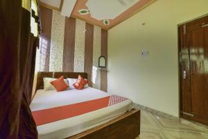 a small bedroom with a bed with red pillows at OYO Flagship Ashoka Guest House in Bihta