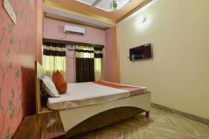 um pequeno quarto com uma cama num quarto em OYO Flagship Ashoka Guest House em Bihta