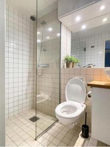 a bathroom with a toilet and a glass shower at Downtown Elegance in Oslo +7 photos