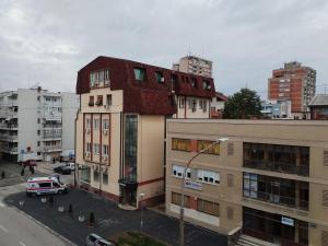 a building with a red roof on a city street at Apartman Petra in Leskovac