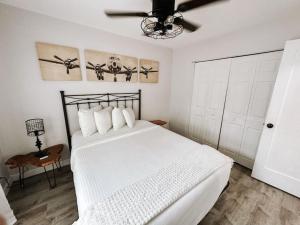 Schlafzimmer mit einem weißen Bett und einem Deckenventilator in der Unterkunft Boho 1BR Apartment in Fort Lauderdale Neighborhood in Fort Lauderdale