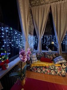 Habitación con sofá en una ventana con luces de Navidad en Iris nel Borgo, en Greve in Chianti