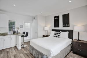 Beach Isles Modern Studio Apartment in Fort Lauderdale في فورت لاودردال: غرفة نوم بيضاء مع سرير كبير ومكتب +6 صور