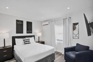 Beach Isles Modern Studio Apartment in Fort Lauderdale في فورت لاودردال: غرفة نوم بها سرير وكرسي