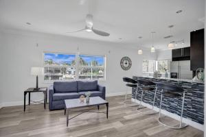een woonkamer met een blauwe bank en een keuken bij Beach Isles Modern 1BR Apartment in Fort Lauderdale in Fort Lauderdale