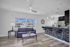 a living room with a blue couch and a kitchen at Beach Isles Modern 1BR Apartment in Fort Lauderdale in Fort Lauderdale