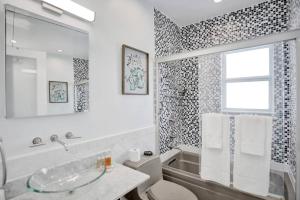 a bathroom with a sink and a tub and a window at Beach Isles Modern 1BR Apartment in Fort Lauderdale in Fort Lauderdale +16 photos