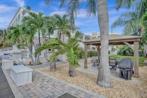 un patio con palmeras y cenador en Beach Isles Modern 1BR Apartment in Fort Lauderdale, en Fort Lauderdale