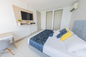 a bedroom with a bed and a desk and a tv at Edificio Palmetto Beach Apto 1702 in Cartagena de Indias