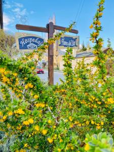 a street sign with yellow flowers in front of a building at Hospedaje Flores del Sur in El Calafate