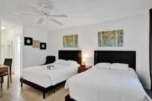 a bedroom with two beds and a ceiling fan at Waves Beach Town Spacious Studio Apartment For 4 People in Pompano Beach +14 photos