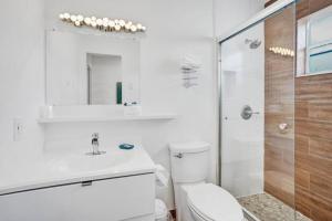 a bathroom with a toilet and a sink and a shower at Waves Beach Town Cozy Studio Apartment in Pompano Beach +9 photos