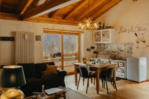 a living room with a couch and a table and a kitchen at Odomi maso nel bosco - Eleganza e Relax nella Natura in Sant'Orsola Terme