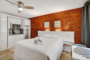 a bedroom with a bed with two towels on it at Waves Beach Town Cozy Studio Apartment in Pompano Beach