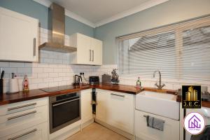 a kitchen with white cabinets and a sink at Clodien House, Great Location, Free Parking in Cardiff