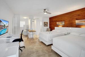 1 dormitorio con 2 camas y escritorio con ordenador en Waves Beach Town Spacious Studio Apartment For 4 People en Pompano Beach