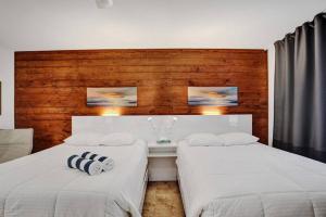 dos camas sentadas una al lado de la otra en un dormitorio en Waves Beach Town Spacious Studio Apartment For 4 People en Pompano Beach