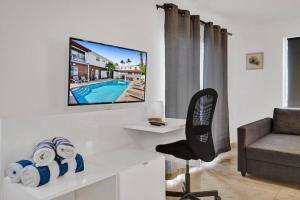 a living room with a couch and a tv on a wall at Waves Beach Town 2BR Apartment in Pompano Beach