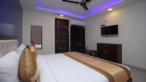 Cette chambre comprend un lit et une télévision. dans l'établissement Airport T Palace, à New Delhi