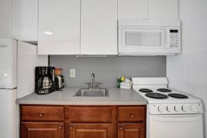 a kitchen with a sink and a stove and microwave at Waves Beach Town Cozy Studio Apartment in Pompano Beach +11 photos