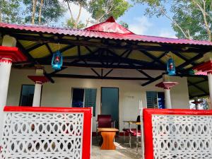a house with a red gate in front of it at Fairy Hills ( Cottage & Park ) in Sreemangal