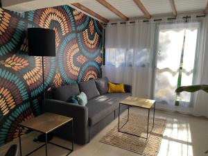 a living room with a couch and a colorful wall at Casa Zizi in Costa Calma