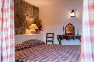 ein Schlafzimmer mit einem Bett und einer Steinmauer in der Unterkunft Casa da Torre, Porto Manso in Ribadouro