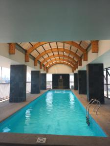 a large indoor swimming pool with a large ceiling at Acogedor y renovado Departamento in Santiago