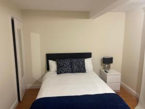 a bedroom with a white bed with a blue blanket at Shared house on Lakewood crescent in Bristol