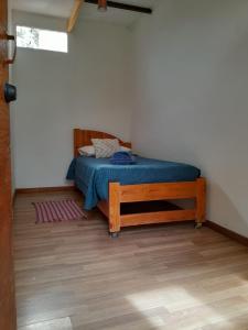 a small bedroom with a bed with a blue blanket at Hotel-Camping Takha Takha in San Pedro de Atacama