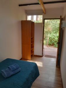 a bedroom with a bed and a sliding glass door at Hotel-Camping Takha Takha in San Pedro de Atacama