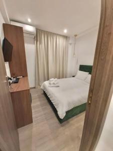 a bedroom with a bed and a television in it at Real City Suites Syntagma in Athens