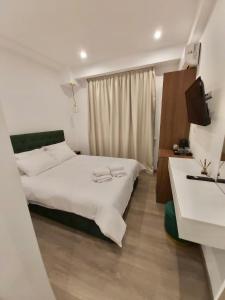 a bedroom with two beds and a television in it at Real City Suites Syntagma in Athens