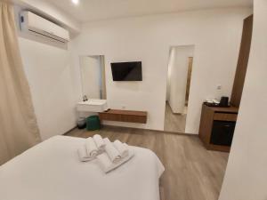 um quarto com uma cama branca e toalhas em Real City Suites Syntagma em Atenas