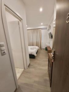 einen Flur eines Hotelzimmers mit einem Bett und einem Spiegel in der Unterkunft Real City Suites Syntagma in Athen