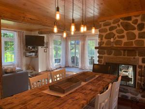 a dining room with a table and a stone fireplace at Bleu Azur 32 night Lakefront Retreat w Hot tub in Saint Adolphe D'Howard