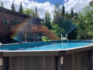 a large swimming pool with a wooden deck on a house at Le Sculptural Exitchalets Laurentides Spa in Val-David
