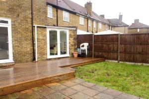 a wooden deck in the yard of a house at Butterfly Home in London