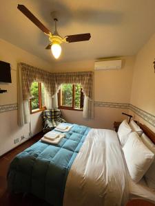 1 dormitorio con 1 cama grande y ventilador de techo en Apto Retro - 500m da Praça das Flores en Nova Petrópolis