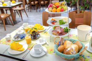 a table topped with plates of food and fruit at Waldhotel Friedrichroda in Friedrichroda