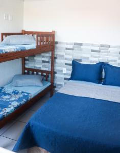 1 dormitorio con 2 literas con sábanas azules en Reduto Praiano - Thaiz Hospedagem, en Cabo Frío